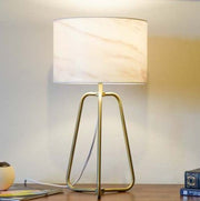 Small modern stylish desk lamp with marble shade and bronze base on table